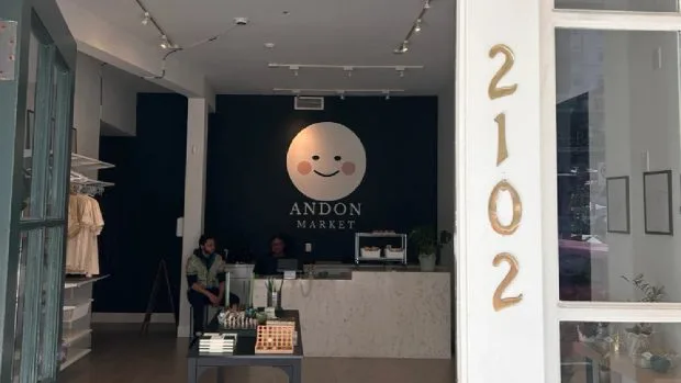 Intrarea unui magazin Andon Market, cu un design modern și logo zâmbitor.