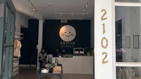 Intrarea unui magazin Andon Market, cu un design modern și logo zâmbitor.