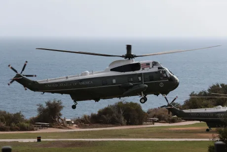 Elicopter militar deasupra unei zone de coastă, în timpul unei misiuni oficiale.