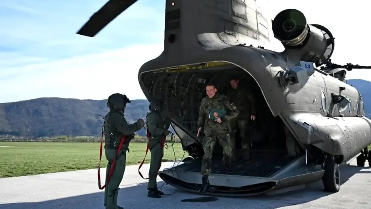 Soldați germani debarcă dintr-un elicopter militar pe un câmp deschis.
