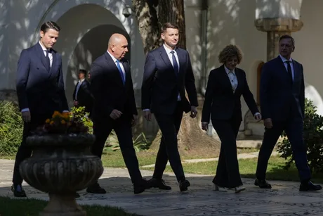 Lideri politici merg pe o alee, discutând despre viitorul guvernului.