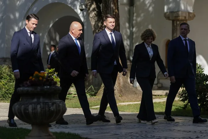 Lideri politici merg pe o alee, discutând despre viitorul guvernului.