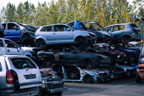 Mașini vechi abandonate într-un parc auto, așteptând reciclarea.