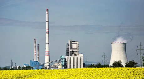 Fabrica de biocombustibili în România, cu turnuri de răcire și câmp de rapiță.