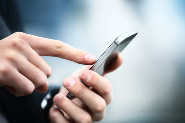 Persoană utilizând un telefon mobil pentru plăți online.