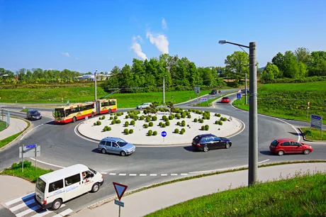 Sens giratoriu cu vehicule în mișcare și semne de circulație vizibile.