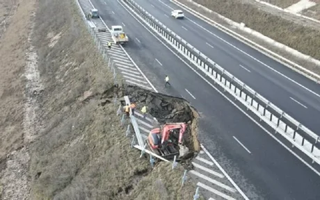 Stâlp de electricitate lăsat în mijlocul drumului, cu sens giratoriu improvizat în jurul lui.