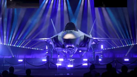 Avion militar expus în lumina reflectoarelor, simbol al securității.