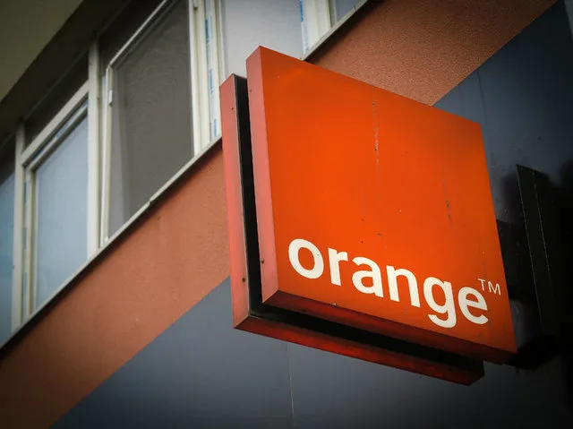 Logo-ul Orange pe fațada unei clădiri, simbolizând inovația în tehnologie.