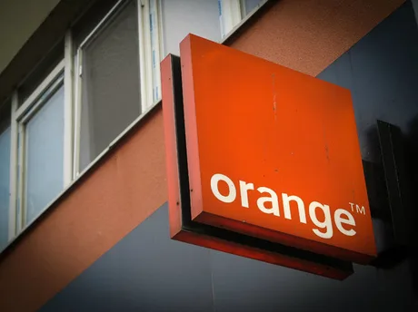 Logo-ul Orange pe fațada unei clădiri, simbolizând inovația în tehnologie.