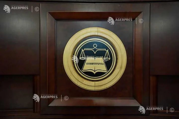 Sigla Curții Constituționale pe fundal de lemn, simbol al justiției.
