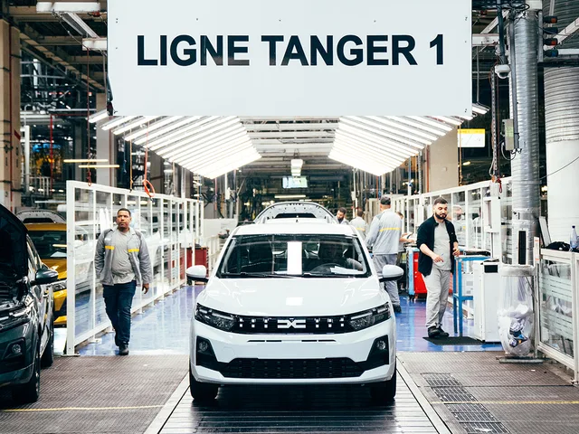 Linia de producție Dacia Sandero în fabrică, cu muncitori activi.