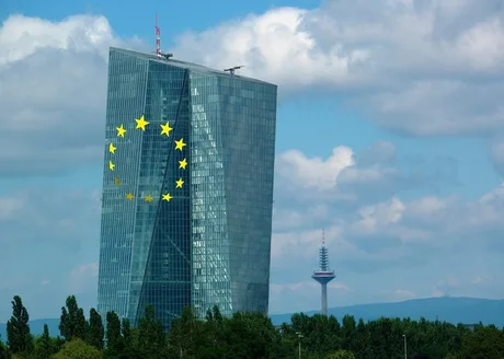 Clădire modernă cu steagul Uniunii Europene pe fațadă, sub un cer senin.