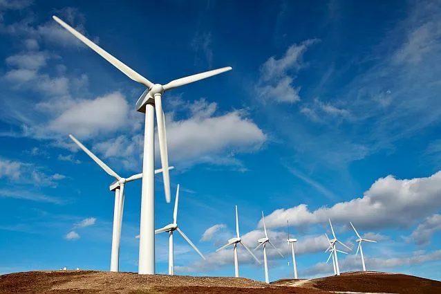 Turbine eoliene pe un fundal de cer senin, simbolizând energia regenerabilă.