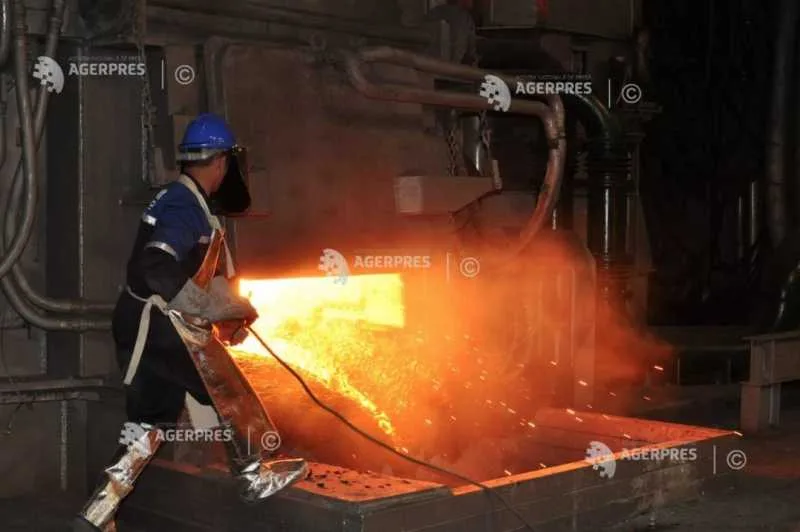 Un muncitor în fabrică, lucrând cu metal topit în condiții industriale.