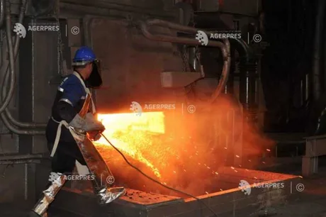 Un muncitor în fabrică, lucrând cu metal topit în condiții industriale.
