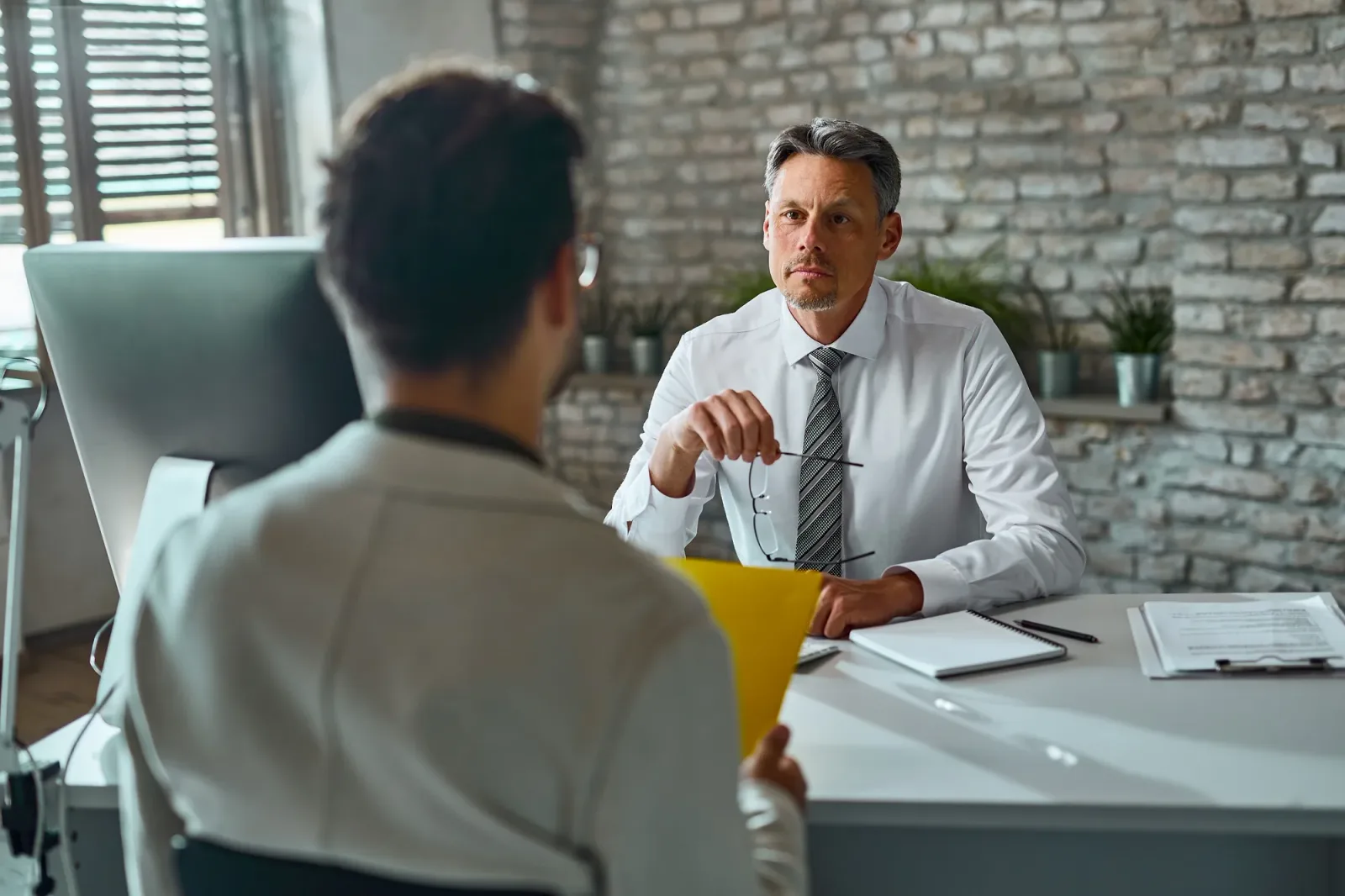 Discuție între un angajator și un candidat într-un birou modern.