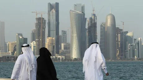 Persoane admirând peisajul urban din Qatar, cu clădiri moderne în fundal.