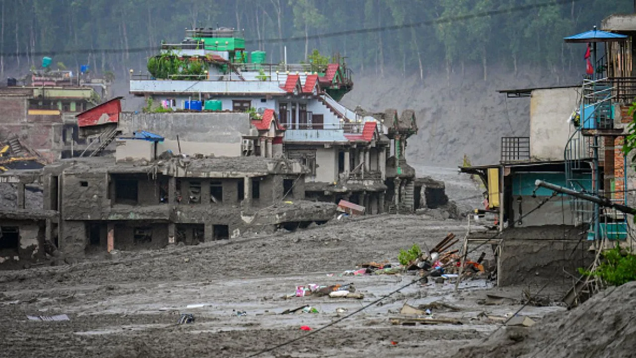 Zone afectate de viituri în Himalaya, clădiri acoperite de noroi și deșeuri.