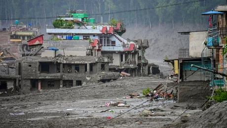 Zone afectate de viituri în Himalaya, clădiri acoperite de noroi și deșeuri.