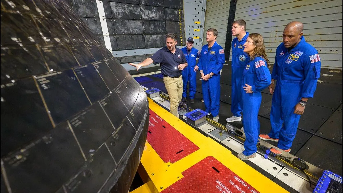 Echipa inspectează scutul termic al capsulei Orion după amerizare.