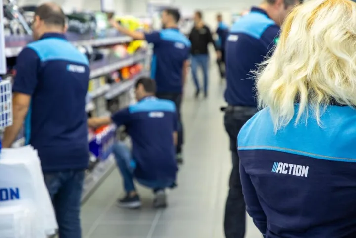 Angajați în magazinul Action din Bistrița, organizând produsele pe rafturi.