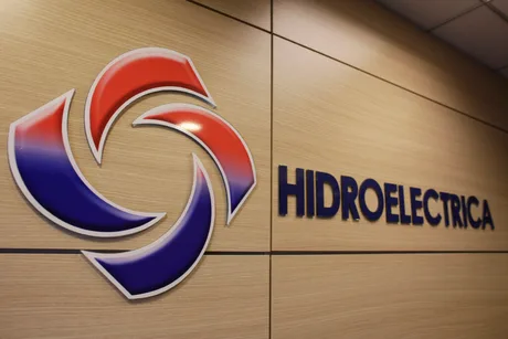 Logo-ul companiei Hidroelectrica pe un fundal de lemn.