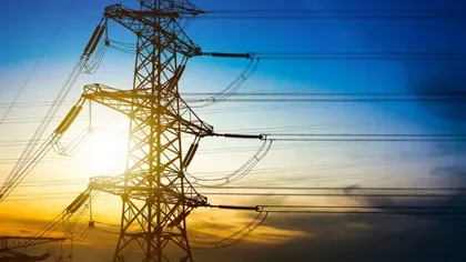 Stâlp de înaltă tensiune la apus, simbolizând energia.