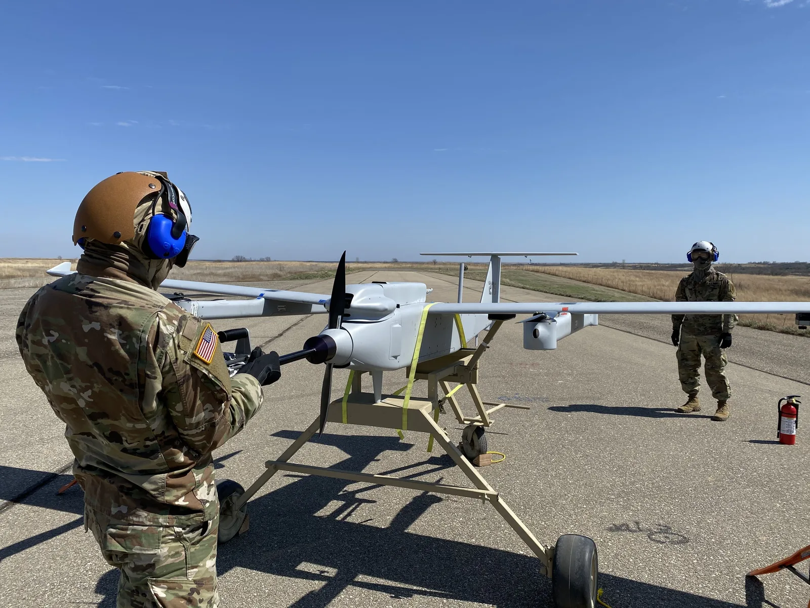 Soldați pregătesc un dron pentru testare pe un poligon militar.