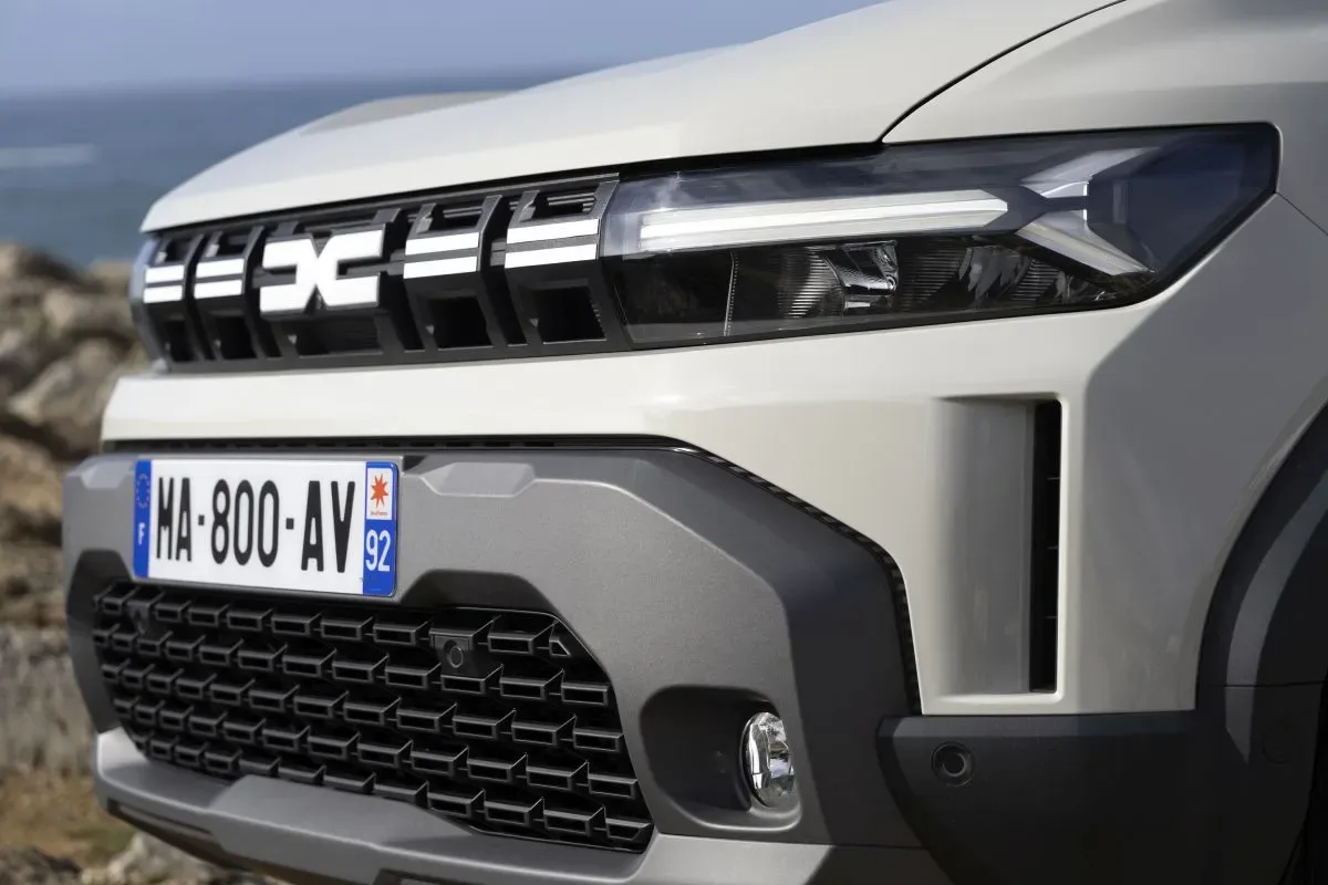 Detaliu al grilei frontale a unui nou model Dacia electric.