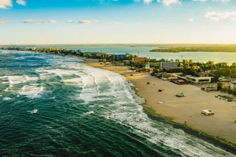 Plaja din Mamaia, cu valuri și peisaj urban în fundal.
