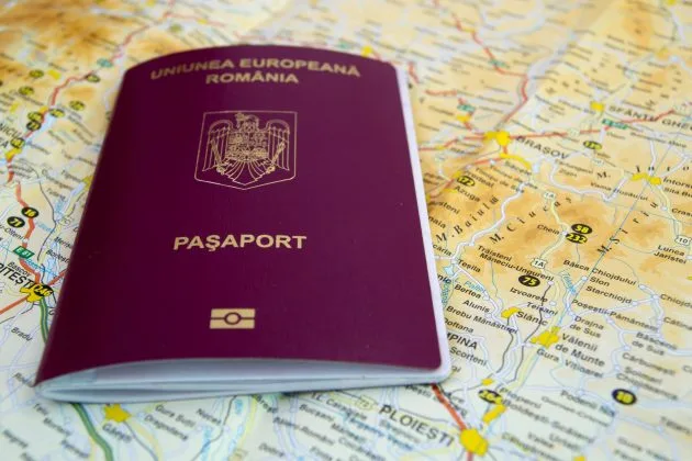 Pașaport românesc pe un fundal de hartă geografică