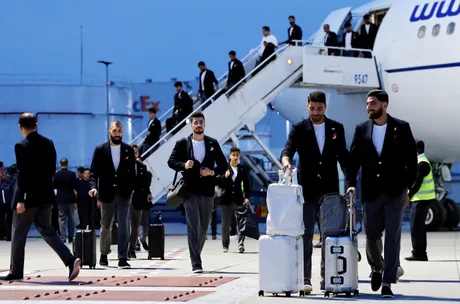Oficialii iranieni sosesc la aeroport cu bagaje, pregătiți pentru competiție.