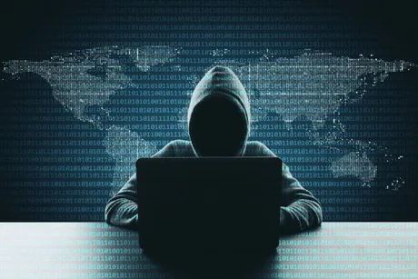 Un hacker lucrează la un laptop, înconjurat de coduri digitale.