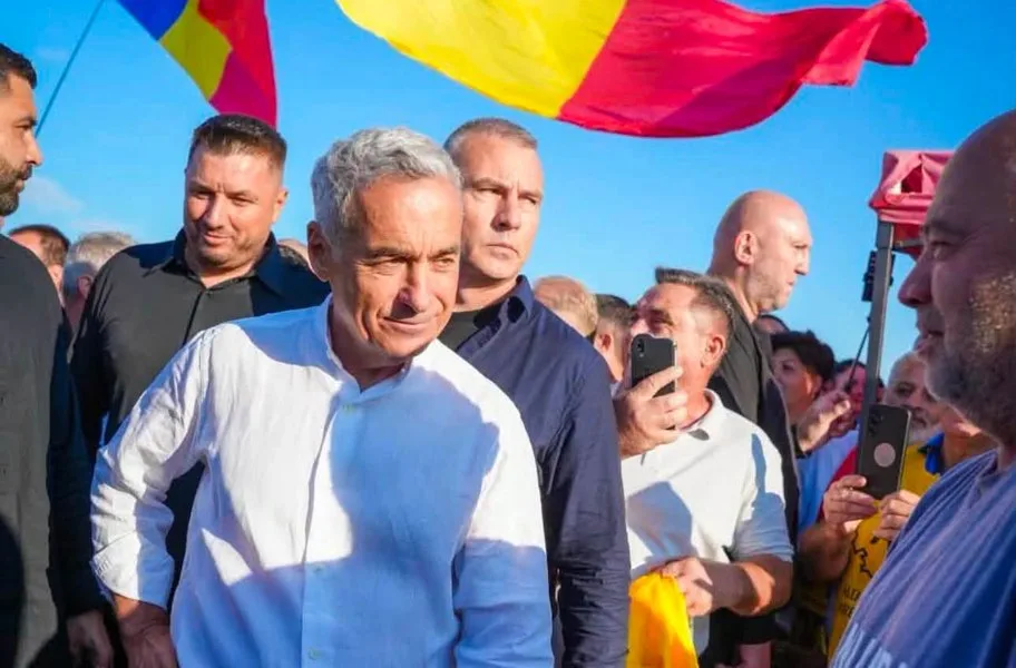 Eugen Tomac la un eveniment, înconjurat de susținători și steaguri românești.