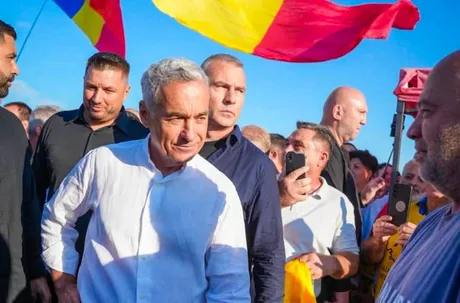 Eugen Tomac la un eveniment, înconjurat de susținători și steaguri românești.