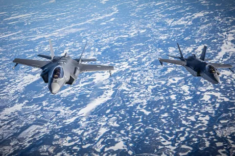 Avioane F-35 zburând deasupra unui peisaj înghețat, simbol al puterii militare.