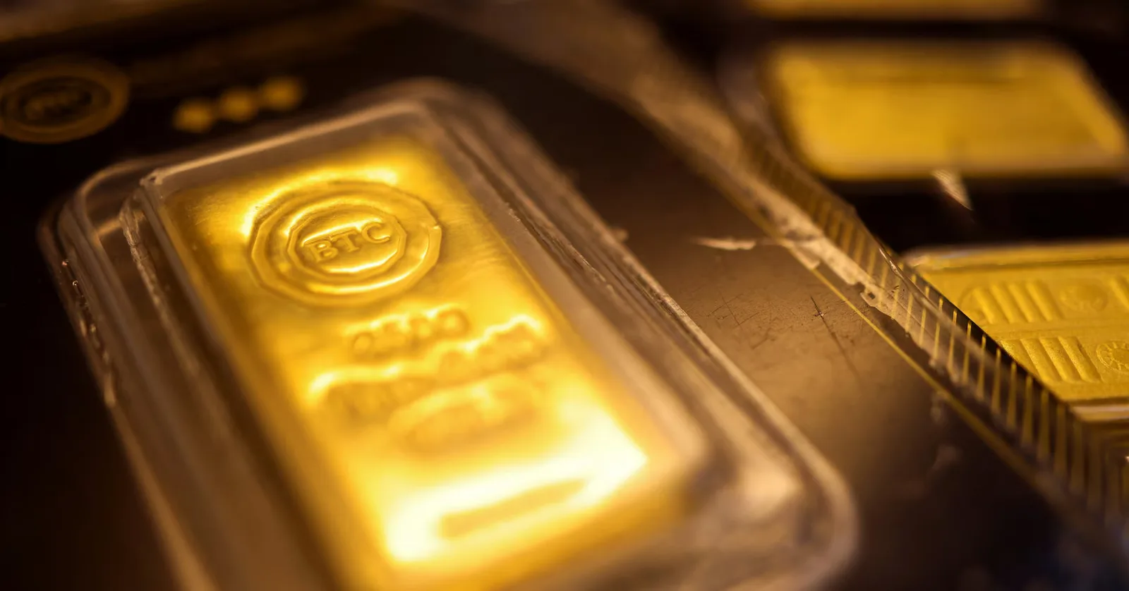 Bucată de aur pe fundal întunecat, evidențiind scăderea prețului metalului prețios.