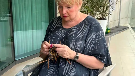 Ambasadoarea Finlandei tricotând șosete tradiționale din lână pe terasă.