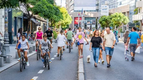 Bucureșteni pe stradă, biciclete și pietoni în aglomerație urbană.