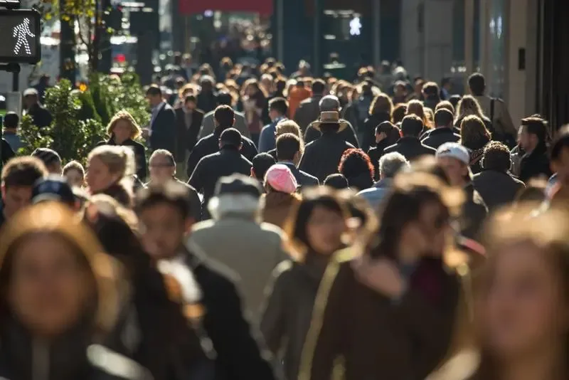 O mulțime de oameni pe o stradă aglomerată într-un oraș.