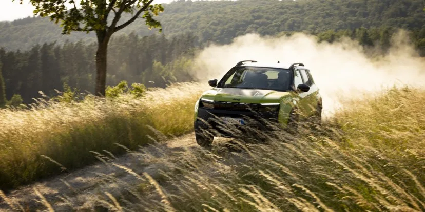 Jeep Avenger reîmprospătat pe un drum de țară, înconjurat de natură.