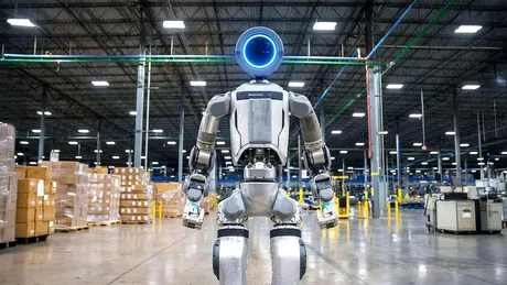 Roboți umanoizi în fabrică, simbol al automatizării în industrie.