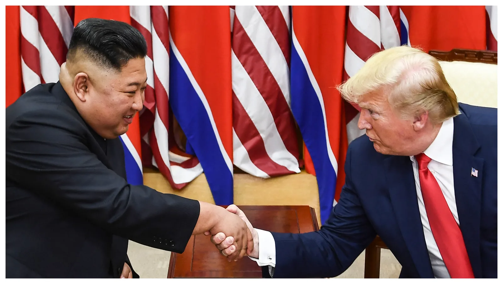 Donald Trump și Kim Jong Un se salută într-o întâlnire anterioară.