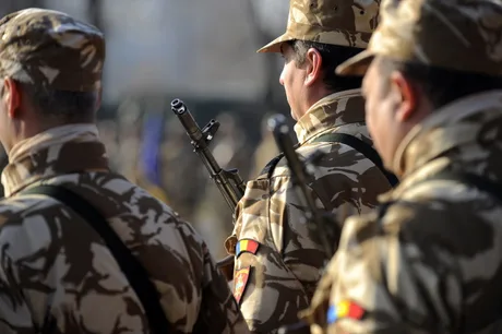 Reprezentanți militari în uniformă, pregătiți pentru o ceremonie oficială.