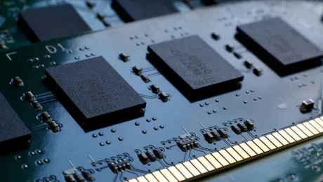 Cipuri DRAM stivuite pe o placă de circuit, inovare în tehnologia memoriei.