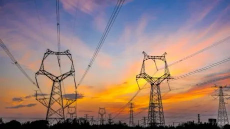 Peisaj urban cu stâlpi de electricitate la apus, simbolizând criza energetică.