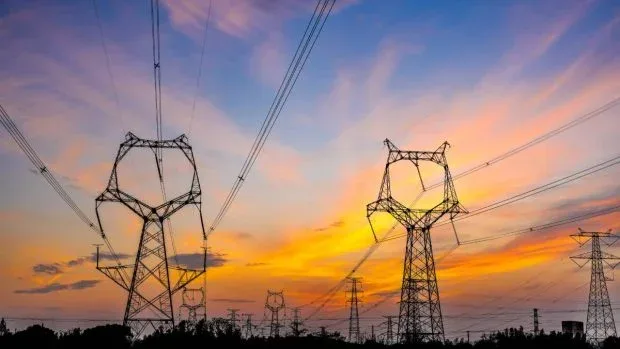 Peisaj urban cu stâlpi de electricitate la apus, simbolizând criza energetică.