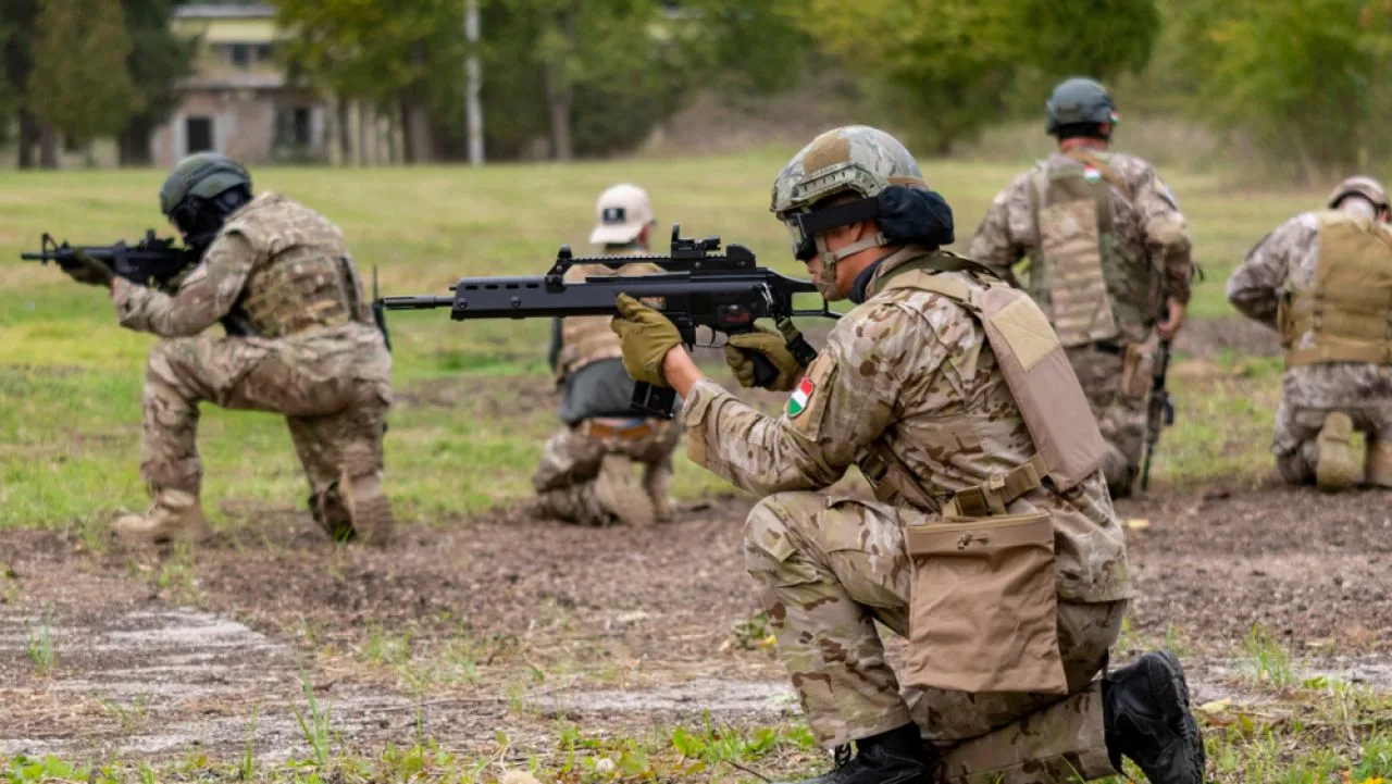 Soldați în exercițiu militar, pregătindu-se pentru misiuni în teren.