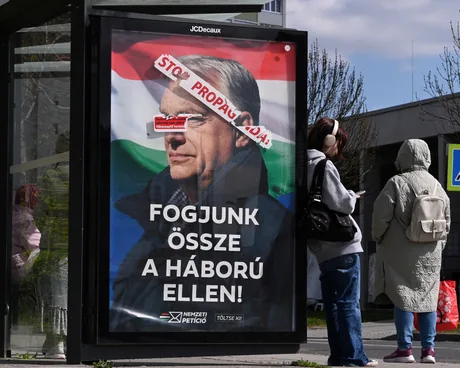 Un afiș electoral în Ungaria, cu un mesaj politic și fundalul steagului național.